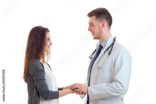 young cute girl with long hair stands opposite the doctor holds his hand and they're smiling