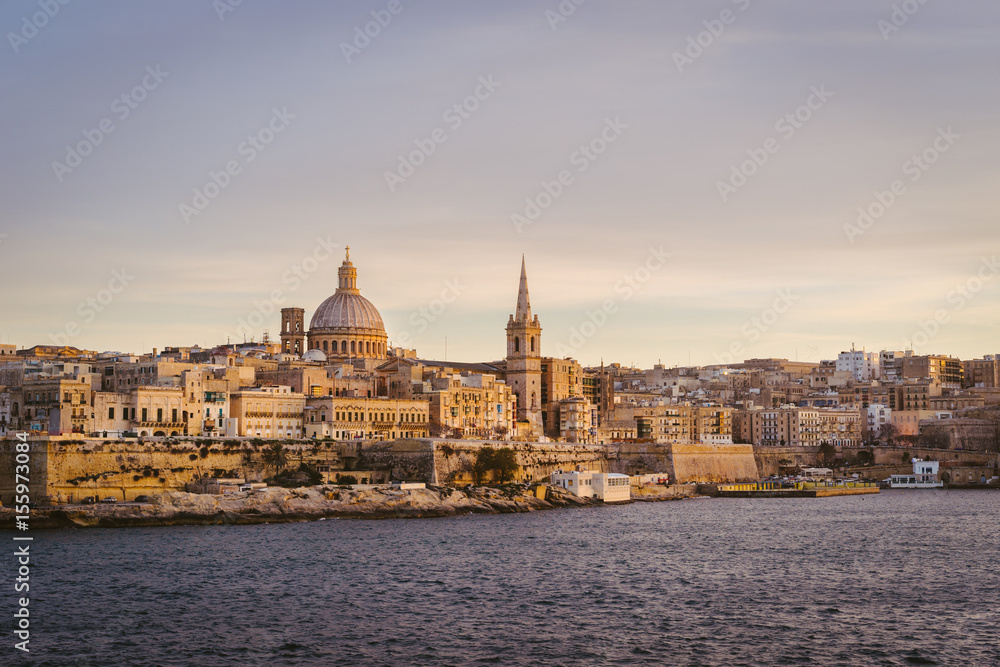 Valletta skyline at sunset with Basilica, viewed from Sliema, Malta