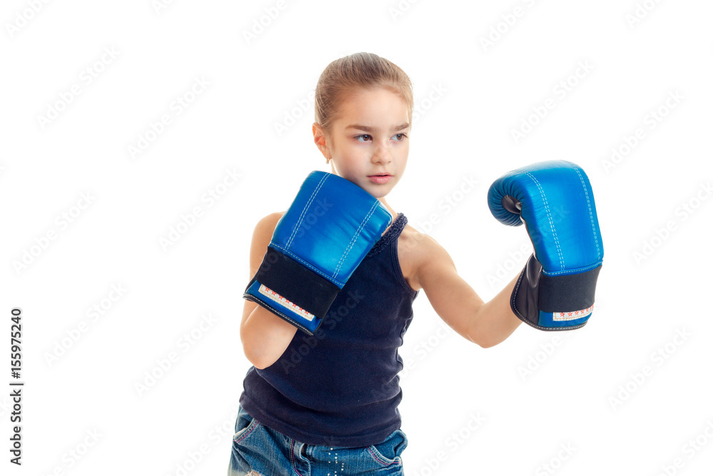 little girl standing in front of the camera in large boxing gloves is isolated on a white background little girl standing in front of the camera in large boxing gloves is isolated on a white background