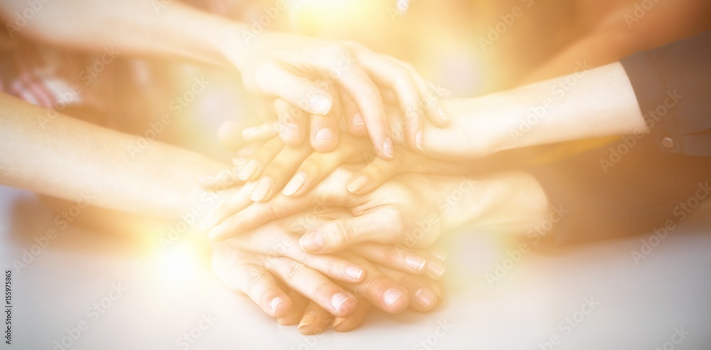 Group of business executives forming hand stack in office Group of business executives forming hand stack in office