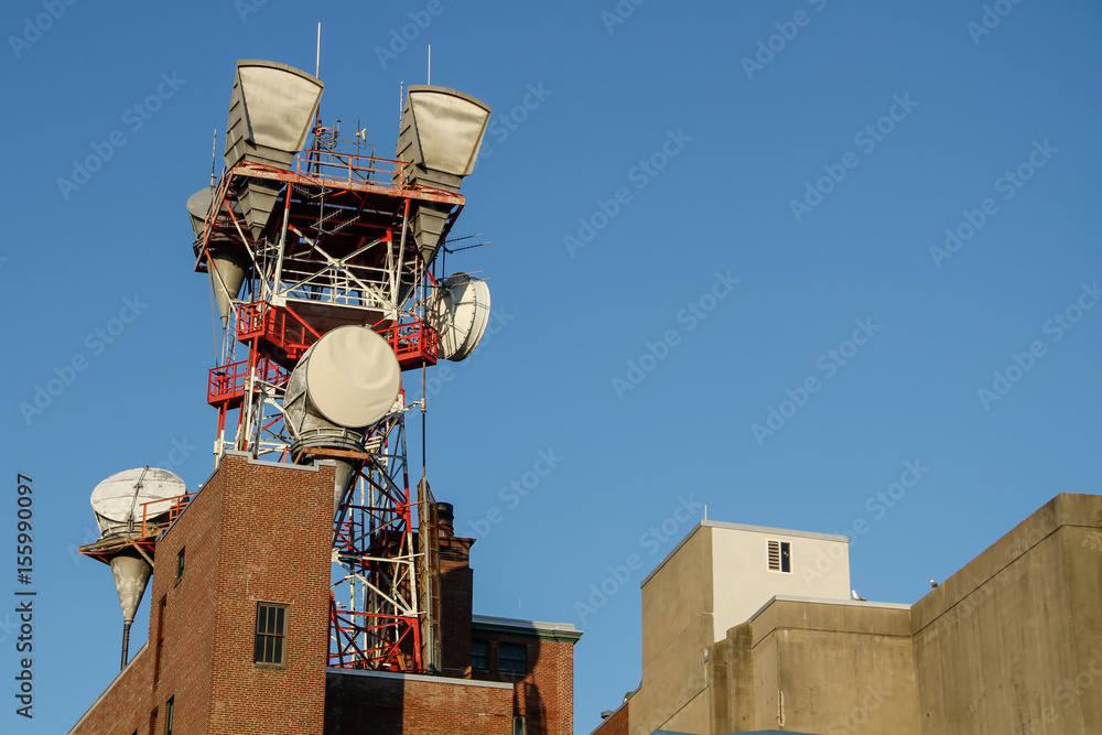Radio antenna on the top of a building, broadcasting concept. Radio antenna on the top of a building, broadcasting concept.