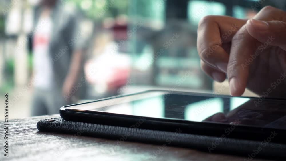 Woman hand using digital tablet in the cafe in the rainy day Woman hand using digital tablet in the cafe in the rainy day