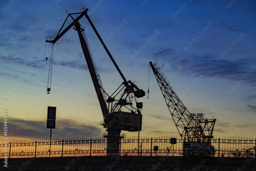 Silhouette view of dock crane with reverse light