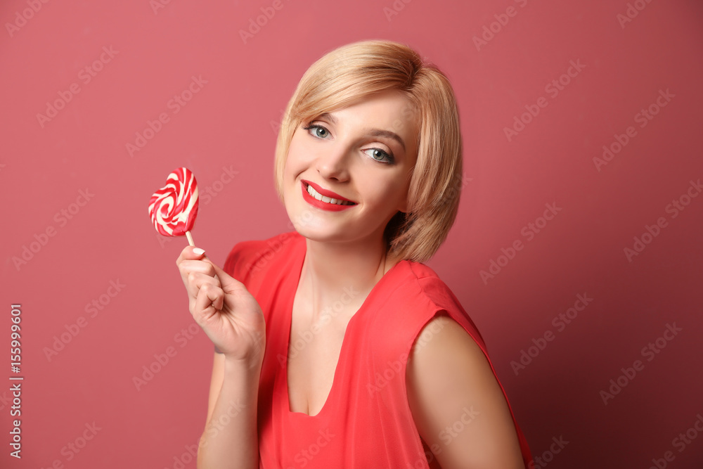 Beautiful woman holding lollipop on color background Beautiful woman holding lollipop on color background
