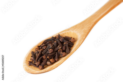 Cloves in wooden spoon isolated on white