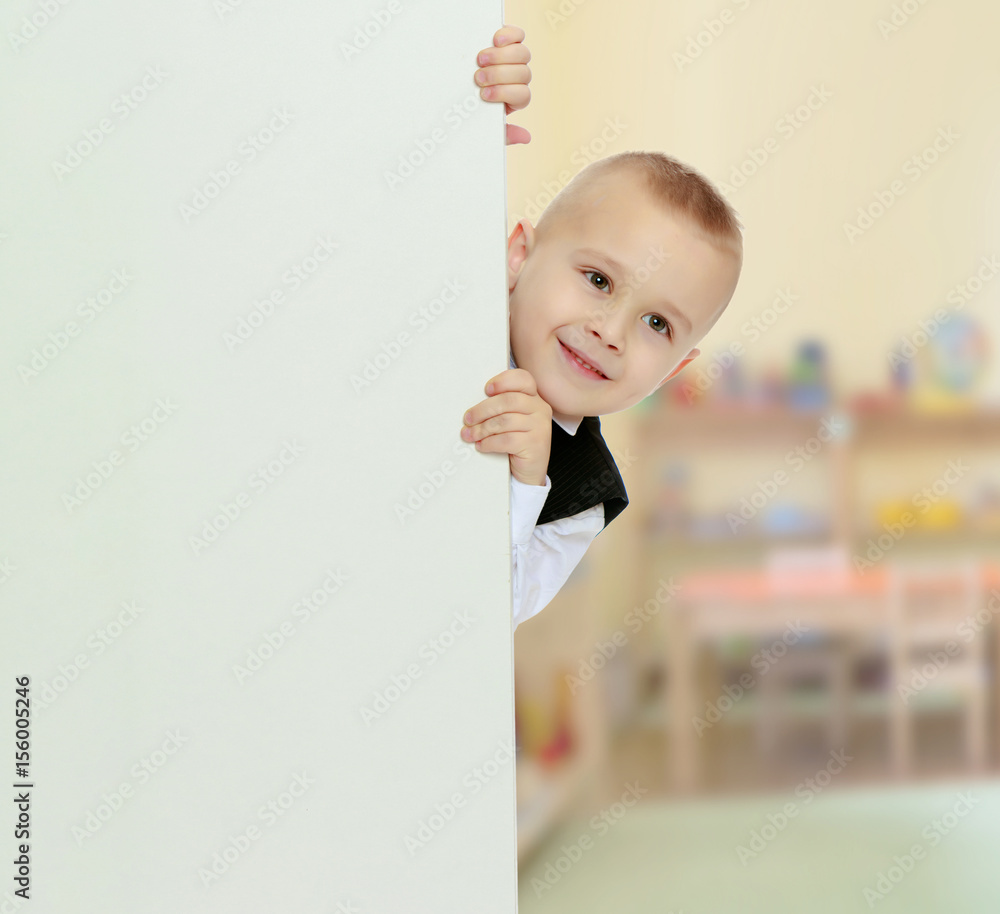 boy peeks out from behind the banner boy peeks out from behind the banner