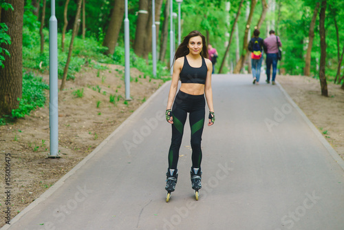 Sports girl in the park on roller skates