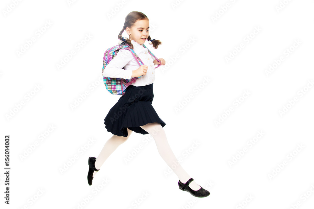 A schoolgirl girl is jumping over obstacles.