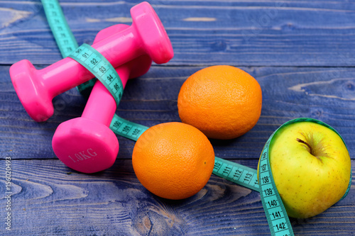 measuring tape, dumbbells weight and apple, orange for diet concept