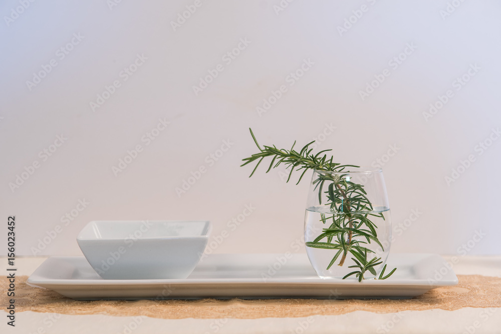 Rosemary in a glass of water on table