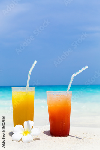 Cocktails in glass on white sandy beach