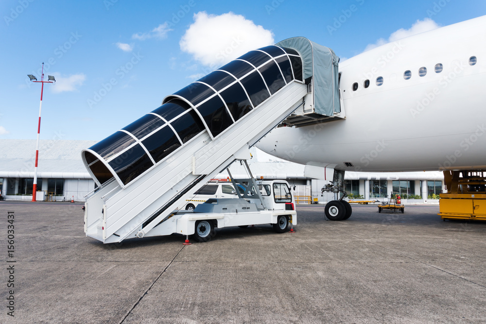 Plane ladder connected to airplane and ready to pass people at the airport Plane ladder connected to airplane and ready to pass people at the airport