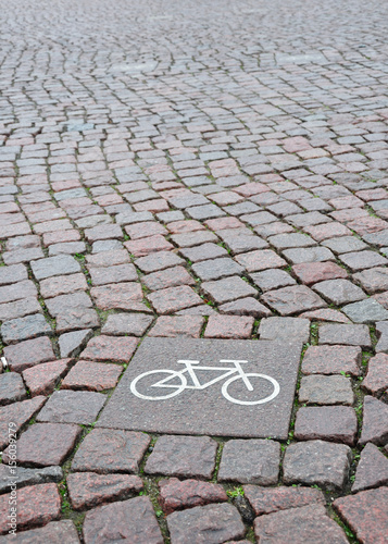 A sign of a bicycle path on a square stone 