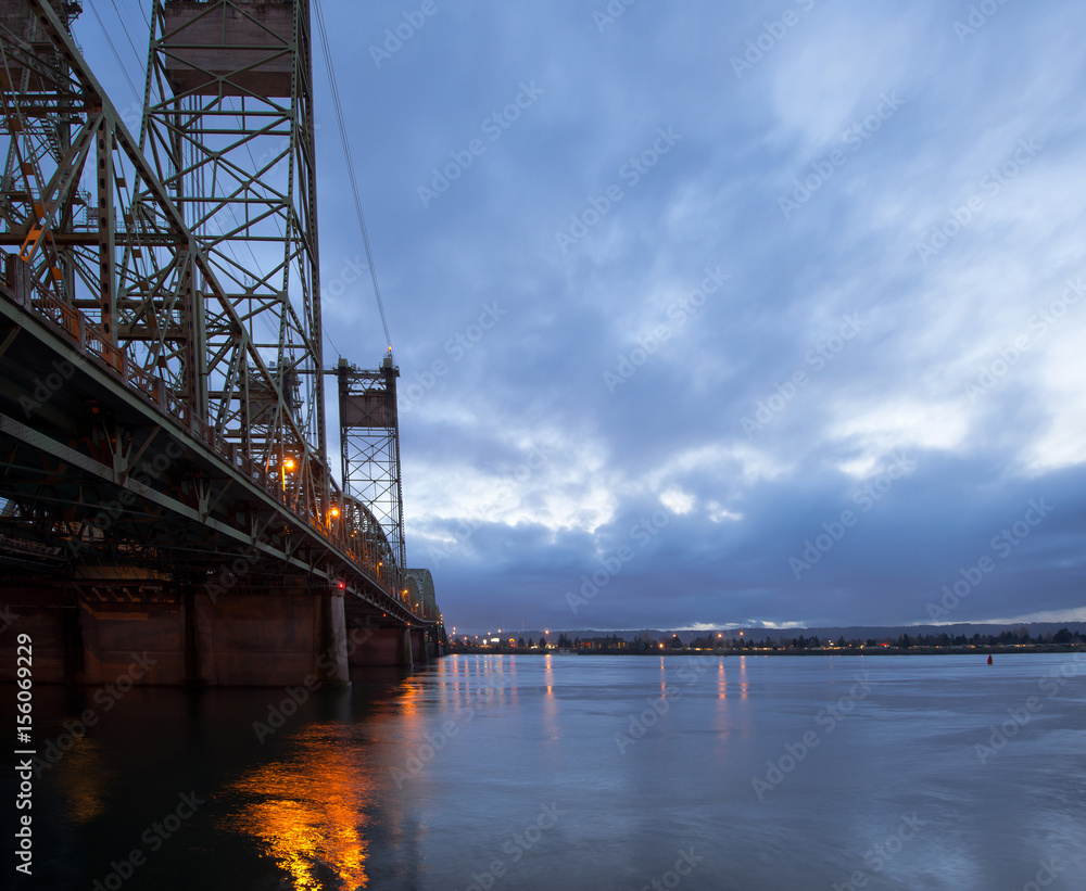 Long drawbridge over Columbia River with night lights reflection