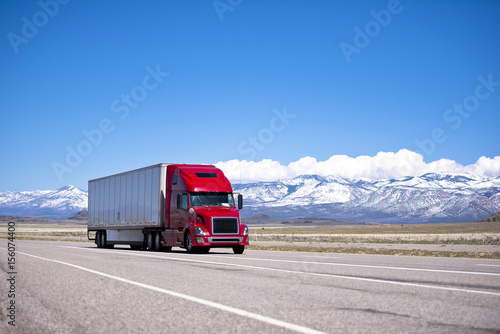 Bright red semi truck modern transportation on spectacular highway