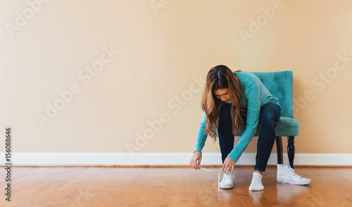 Young latina woman tying her shoes