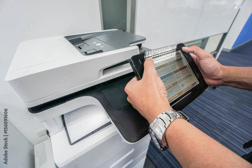businessman hold touch screen for printing document from office printer machine businessman hold touch screen for printing document from office printer machine