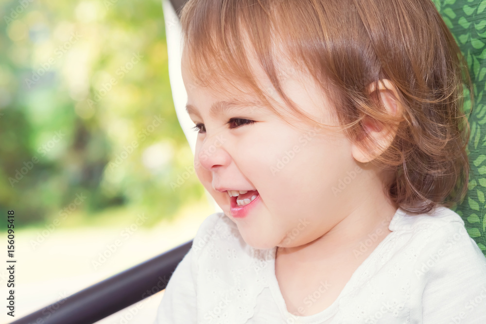 Happy toddler girl laughing while playing on a swing Happy toddler girl laughing while playing on a swing