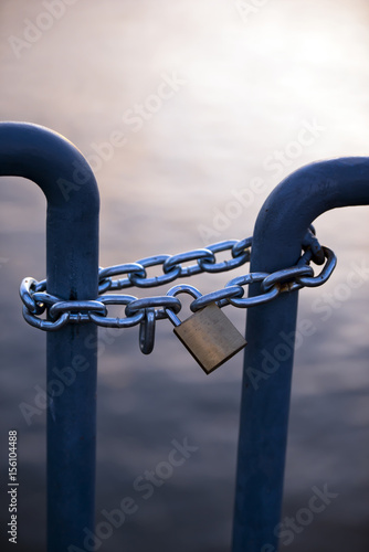 Lock on chain connecting barrage turnstile evening photo
