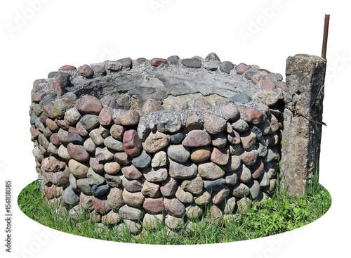 The old destroyed rural well is made of small granite cobble stones photo