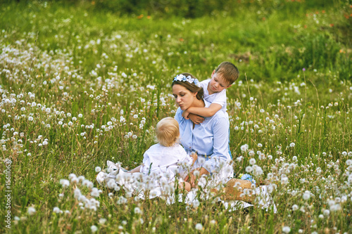 Young mother playing with children in nature. Concept of happy family