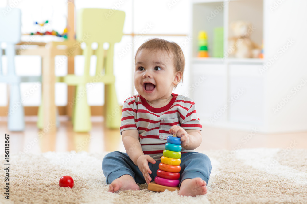 Baby child playing with educational pyramid toys at home. Little kid have fun indoors Baby child playing with educational pyramid toys at home. Little kid have fun indoors