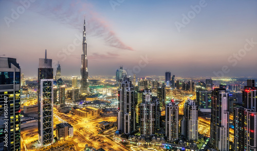 Fantastic aerial view of Dubai, UAE, at sunset. Futuristic architecture of a big modern city in dramatic light. Colourful nighttime skyline. Travel background.