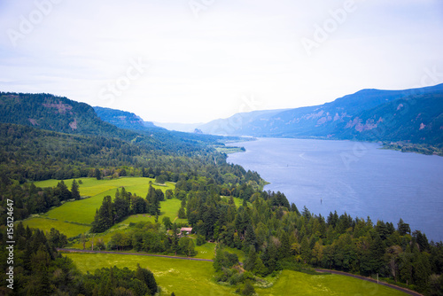 Panorama hilly banks river covered lush green trees leaving blue perspective © vit