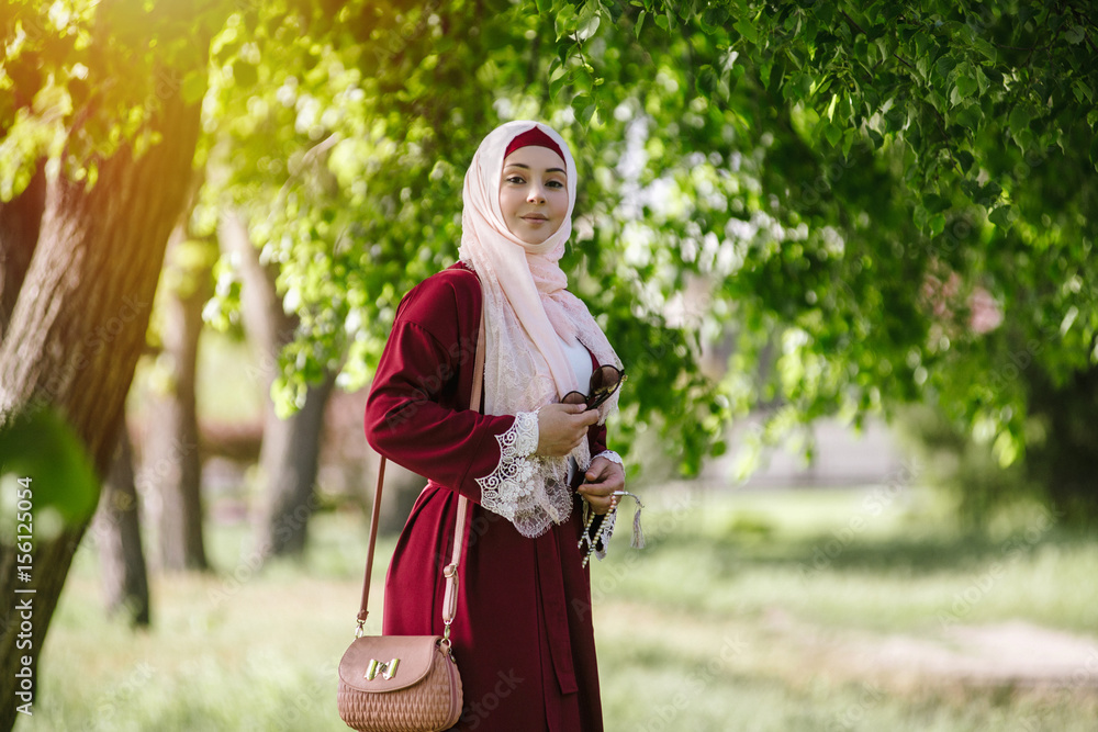 Smiling girl in hijab, happy Muslim woman in summer in the park