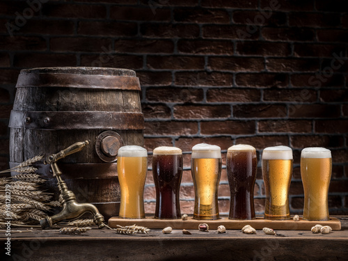 Glasses of beer and ale barrel on the wooden table. Craft brewery. photo