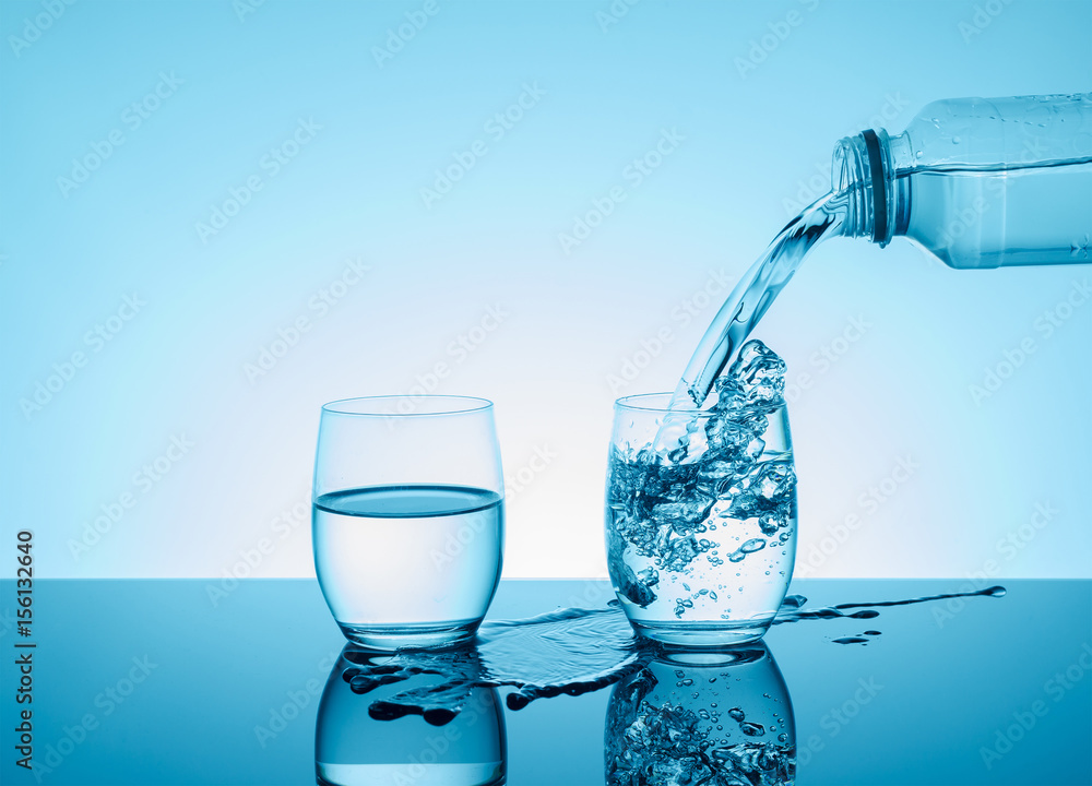 Bottle with creative splashing water in the glass Bottle with creative splashing water in the glass