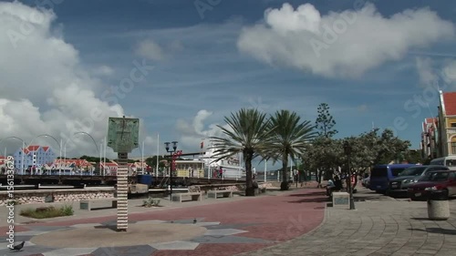 Pan across the waterfront of Willemstad, Curacao from the Queen Emma Bridge to the statue in from to the Governors Palace photo