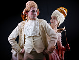 Man and woman in ancient costumes and white wigs