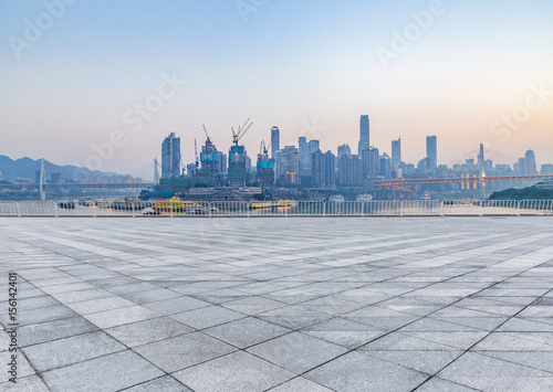 cityscape and skyline of chongqing from empty brick floor at night