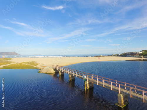 Bridge over the Lagoon to the Ocean with Blue Skies and Clouds