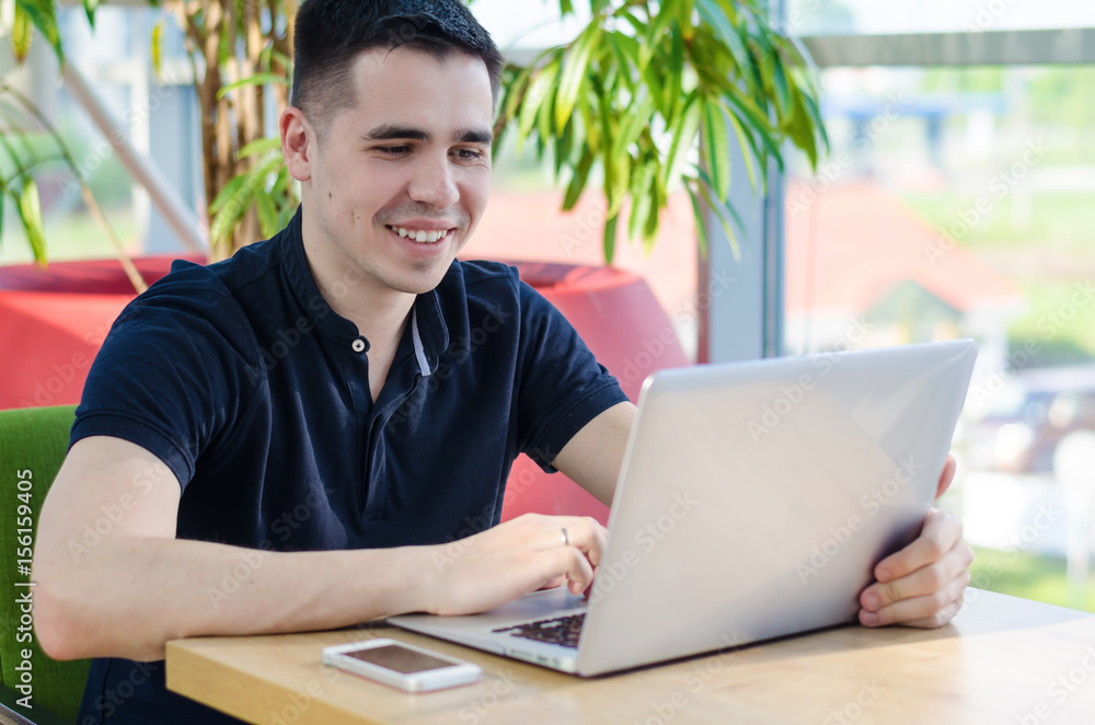 Young man is working, freelance concept, stylish interior, online shopping, focus on the man Young man is working, freelance concept, stylish interior, online shopping, focus on the man