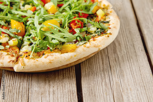 Traditional vegetarian Italian pizza with cheese, arugula, peppe