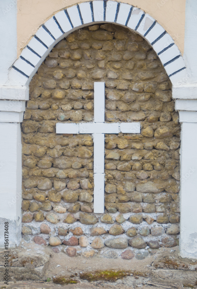 Christian cross over an old stone wall