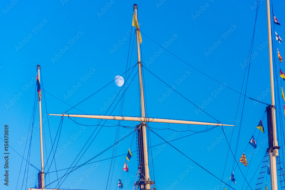 moon in the daytime sky above ships mast moon in the daytime sky above ships mast