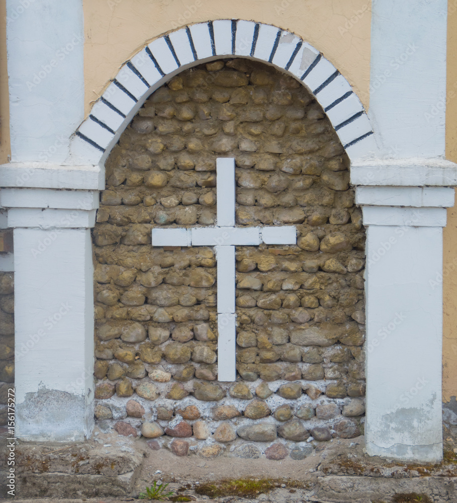 the cross of bricks in the wall of the Church.