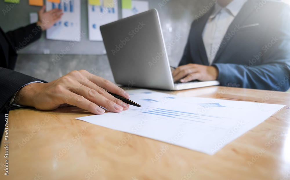 two business executives analyzing data paper at meeting room two business executives analyzing data paper at meeting room