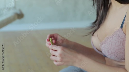 Wallpaper Mural Beautiful brunette girl in beige bra sits and eats something in aluxury studio in slo-mo Torontodigital.ca