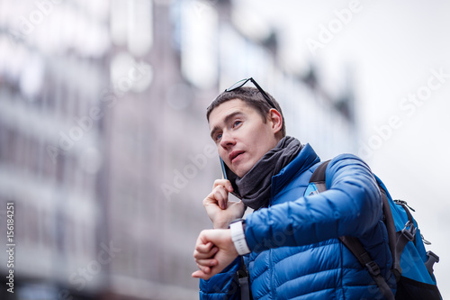 Man talking on phone and looking at smartwatch