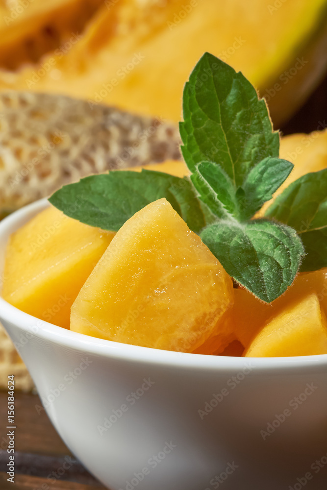 Sweet ripe cantaloupe melon cut and served with mint leaves Sweet ripe cantaloupe melon cut and served with mint leaves