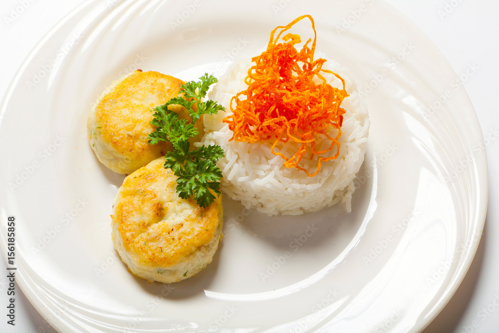 cutlets with herbs and rice on a plate. White background