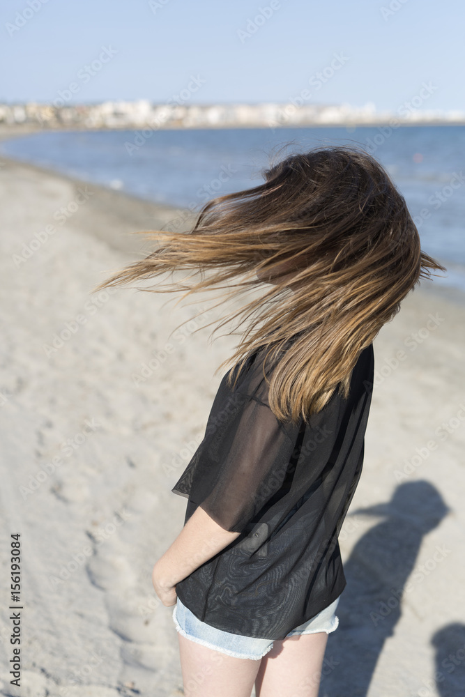 Teenage girl moving her hair on the beach. Teenage girl moving her hair on the beach.