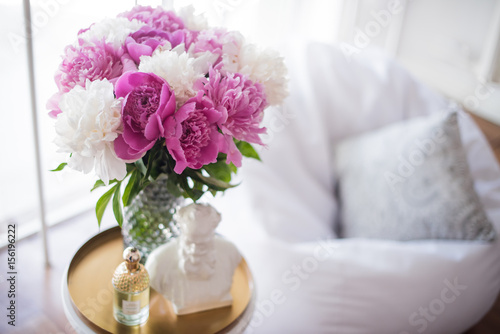 home decoration, fresh pink peonies on coffee table in white roo © Daria Minaeva
