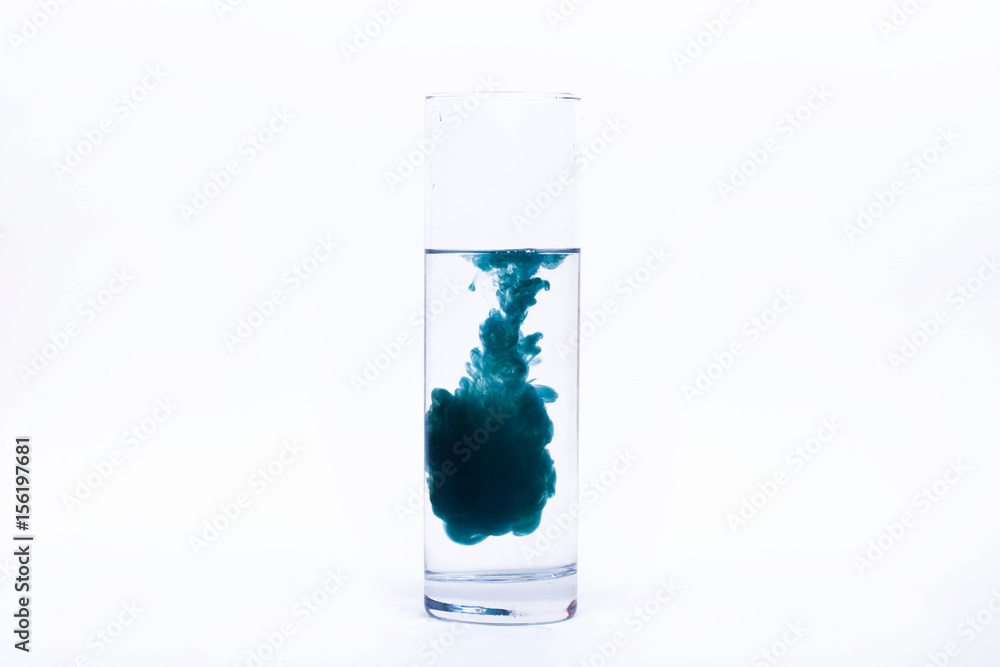 Blue paint falls in a glass with water Blue paint falls in a glass with water