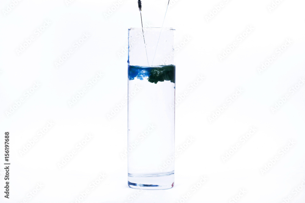 Blue paint falls in a glass with water Blue paint falls in a glass with water