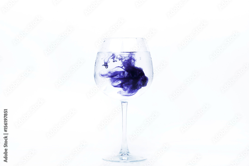 Violet paint falls in a wineglass with water Violet paint falls in a wineglass with water